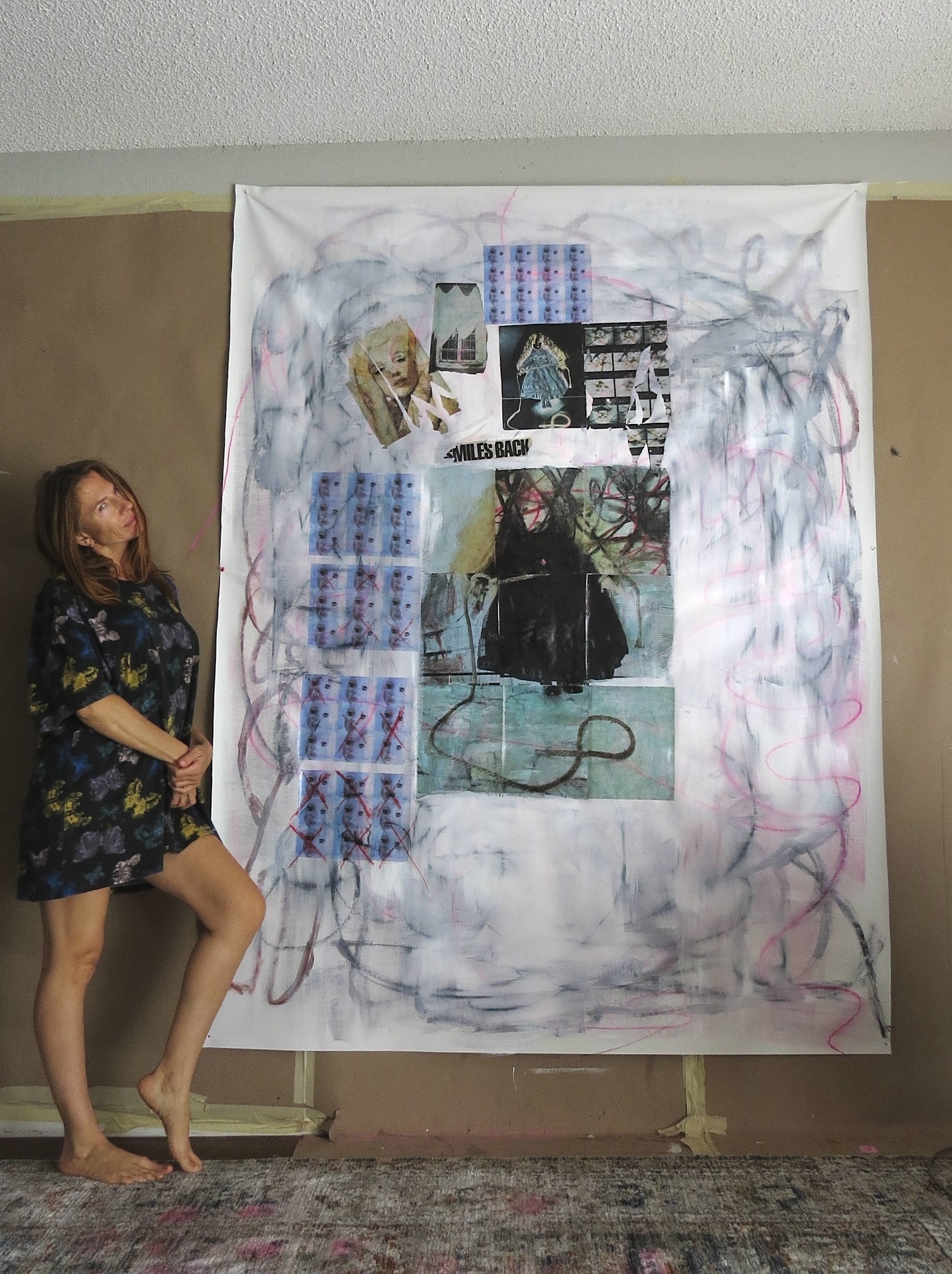 Marina Orlova viewing large mixed media collage artwork in studio