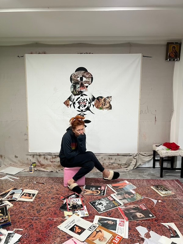 Marina Orlova posing with collage artwork in studio
