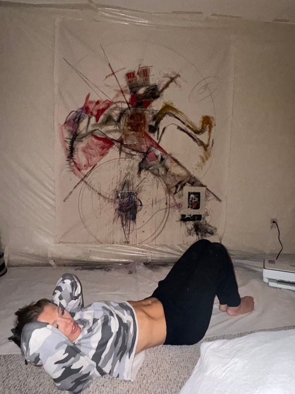 Marina Orlova lying beneath abstract wall painting in studio