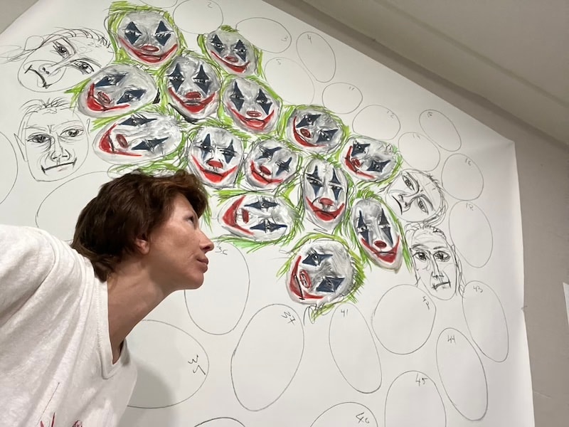 Marina Orlova studying Joker faces mural in progress in studio