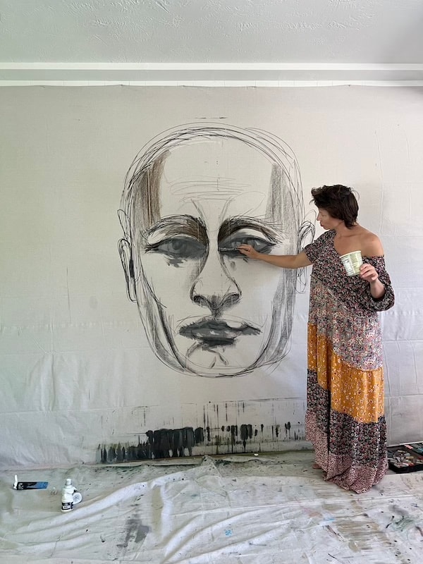 Marina Orlova painting large portrait mural on studio wall