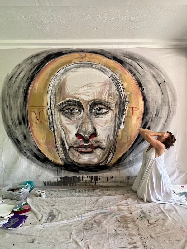 Marina Orlova painting large portrait mural on studio wall