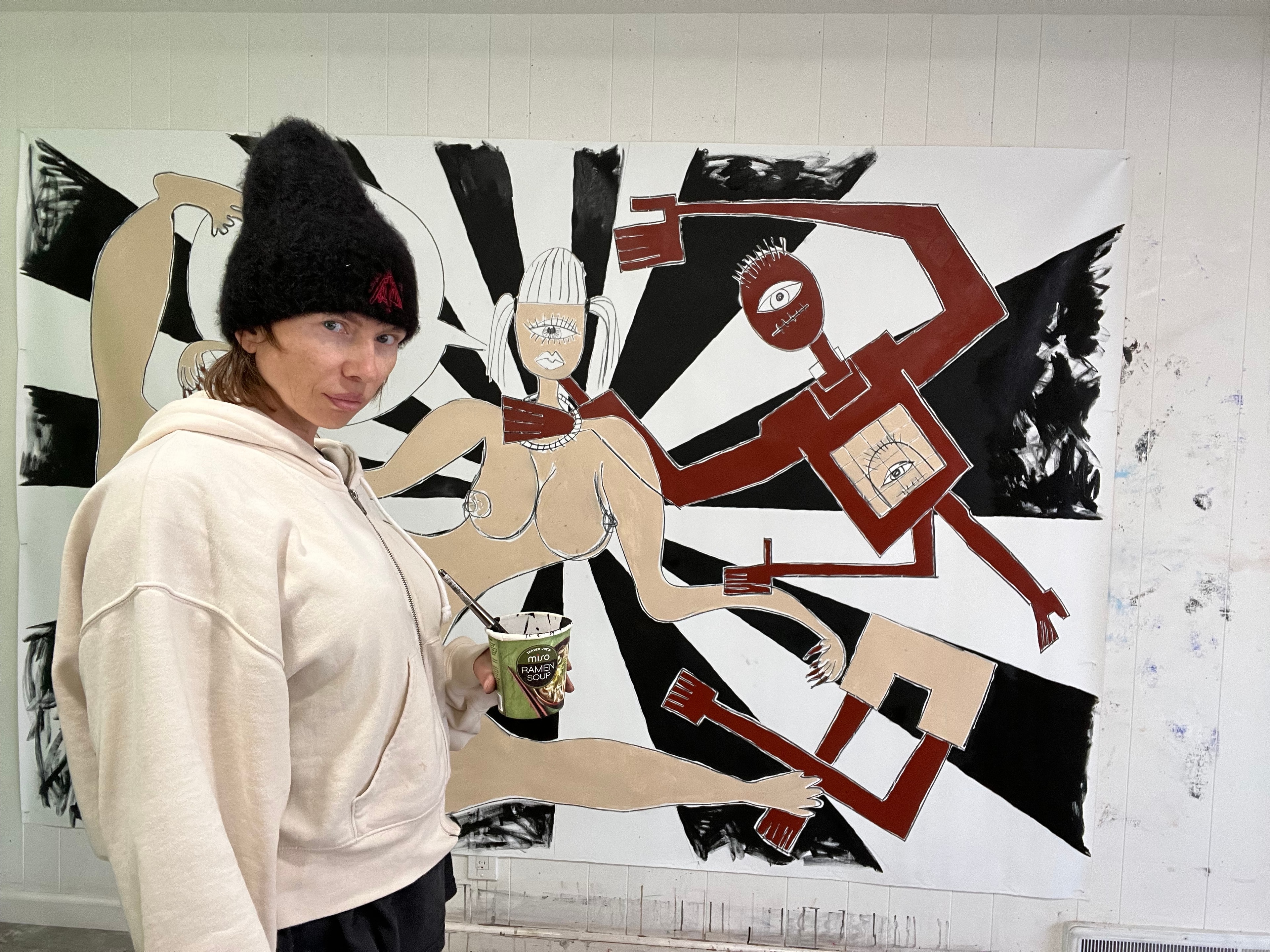 Marina Orlova posing with large abstract figure mural in progress