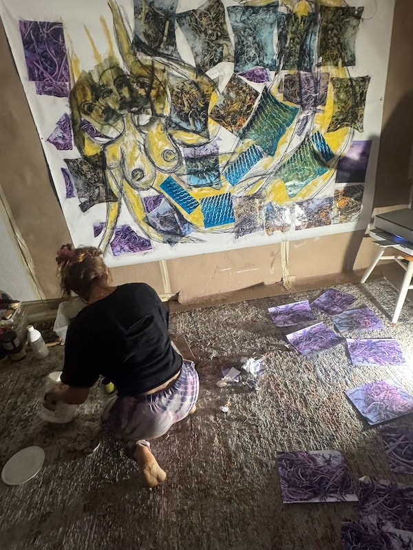 Marina Orlova arranging collage artwork on studio floor