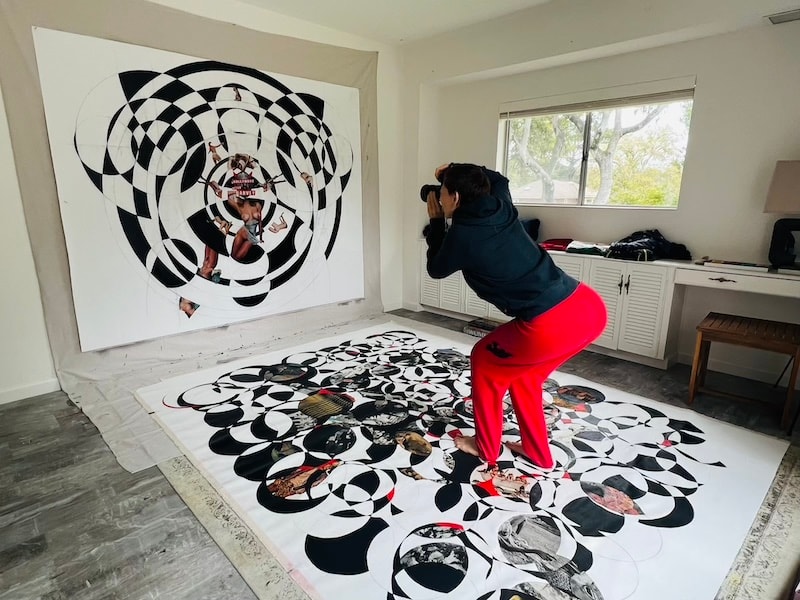 Marina Orlova photographing large black-and-white collage in studio