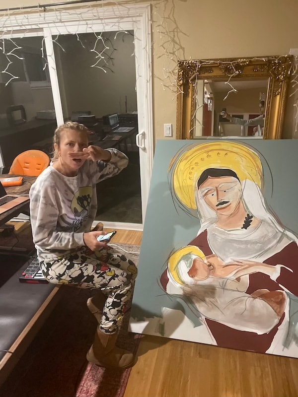 Marina Orlova posing with religious portrait painting in studio