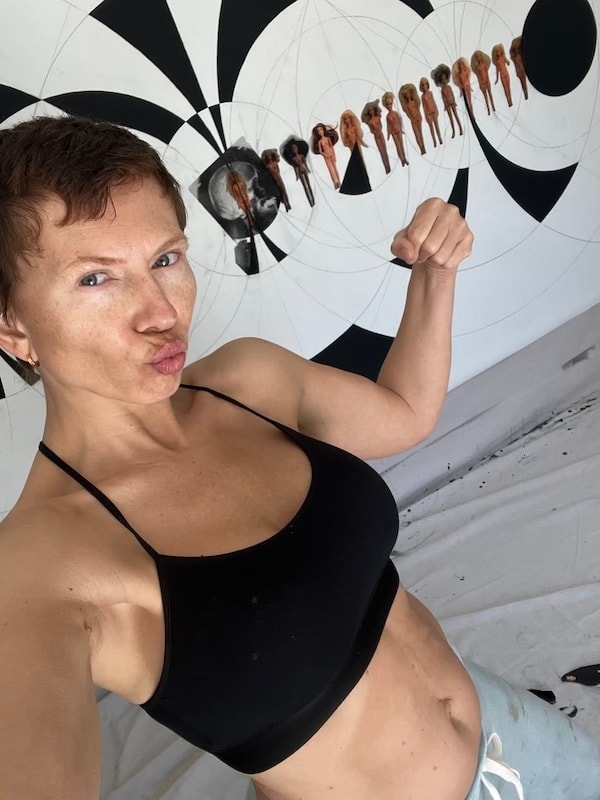Marina Orlova posing with abstract art installation outdoors