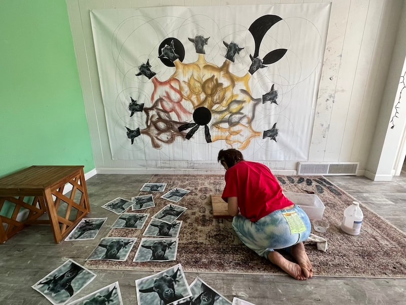Marina Orlova arranging photographs beneath large brain artwork