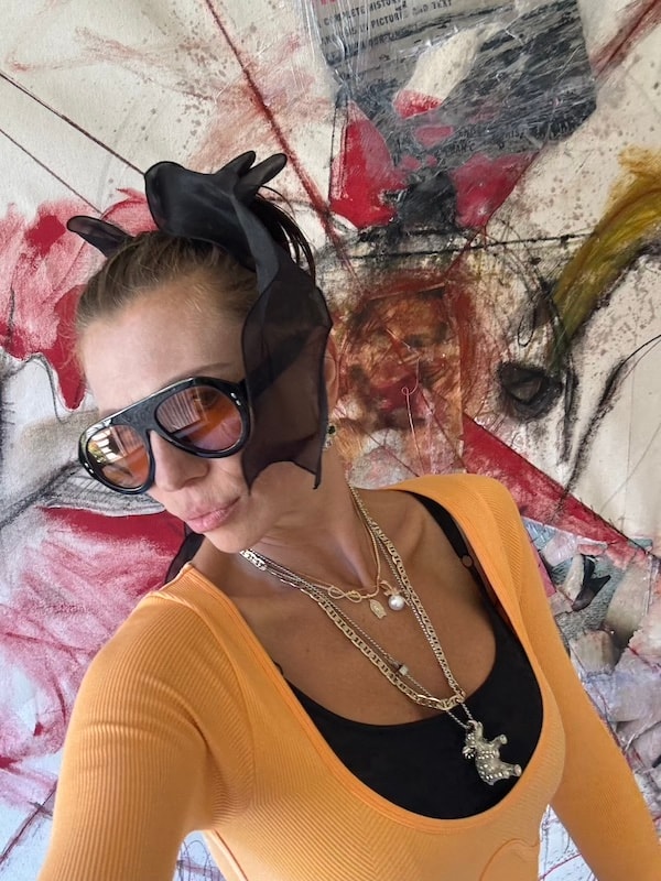 Marina Orlova posing against colorful abstract art in studio